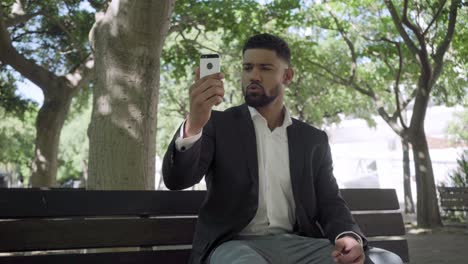 Smiling-bearded-man-having-video-call-through-smartphone.